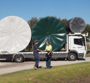 Polymaster truck delivering to a farm, installer and recipient shaking hands