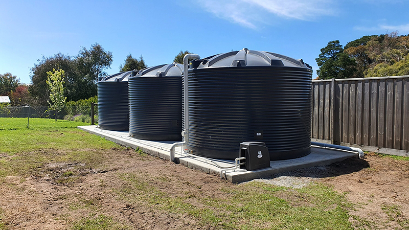 Three Polymaster 31,700L Water Tanks installed in a backyard