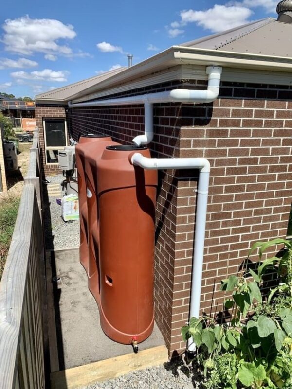Polymaster 3000L Red Slimline installed behind a house with visible pipework