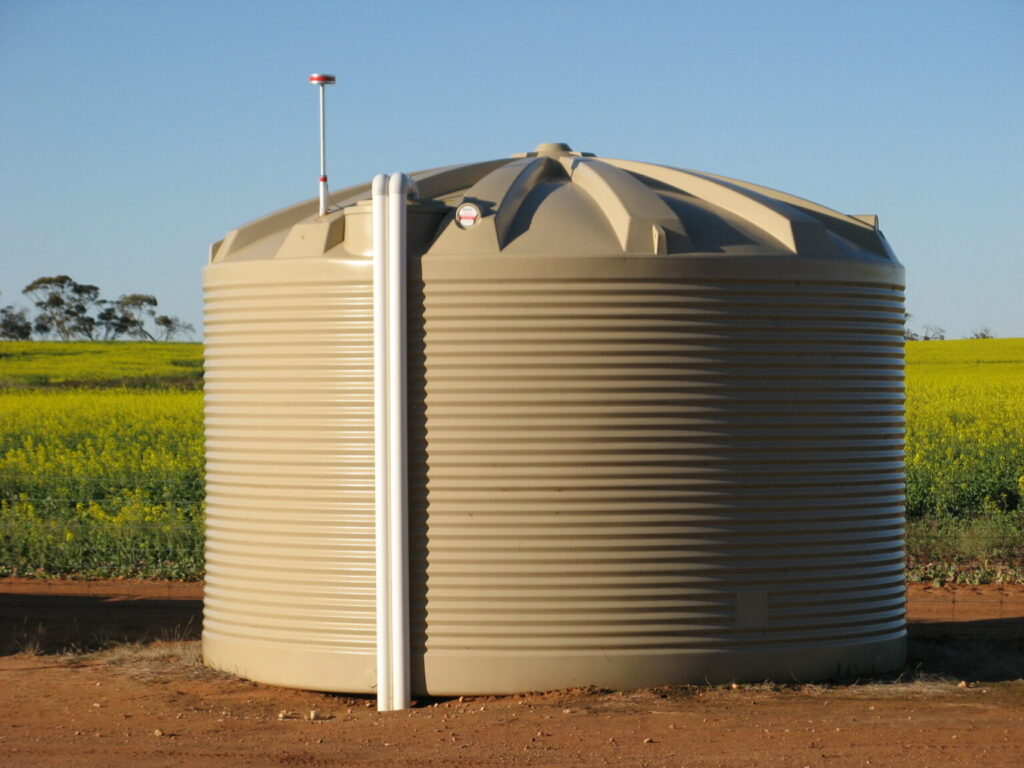 Rainwater Tank installed in a field, with visible pipework