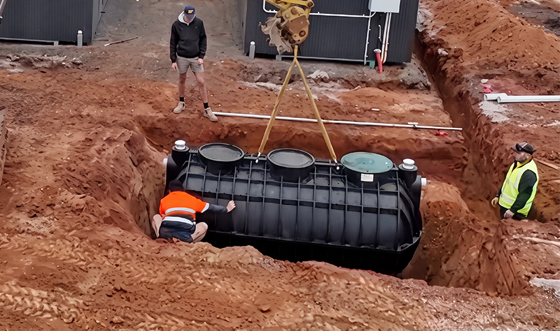 Polymaster Septic Tank being lowered by crane and installed by three mean