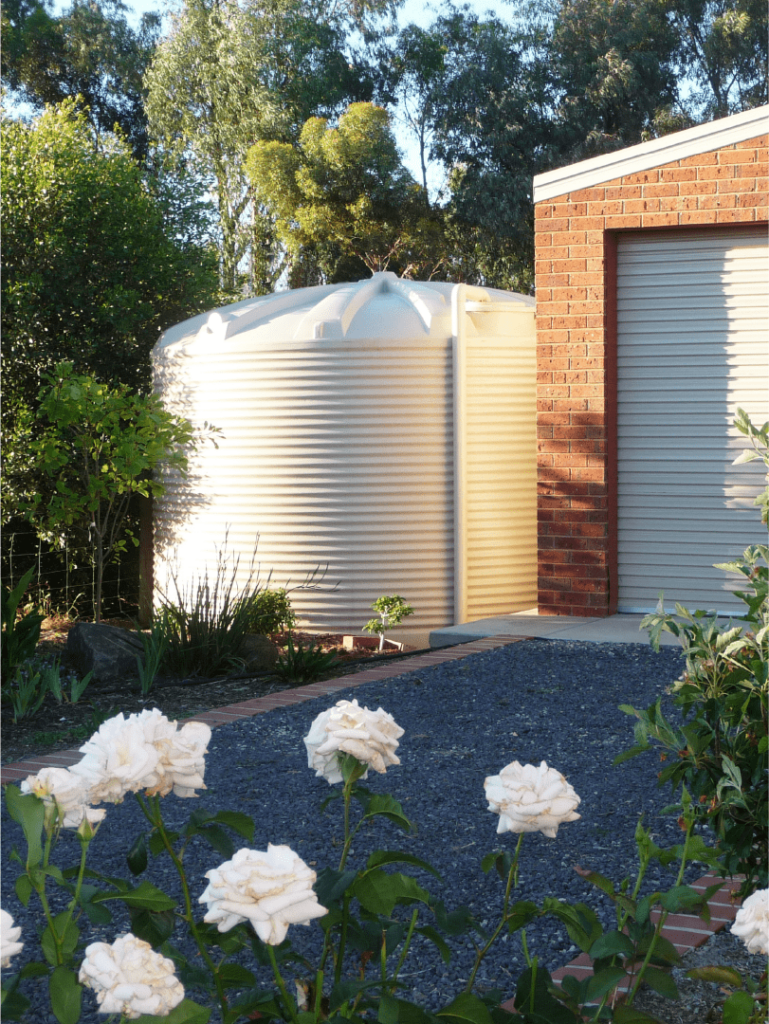 Polymaster Round Water Tanks installed beside a garage shed under huge trees