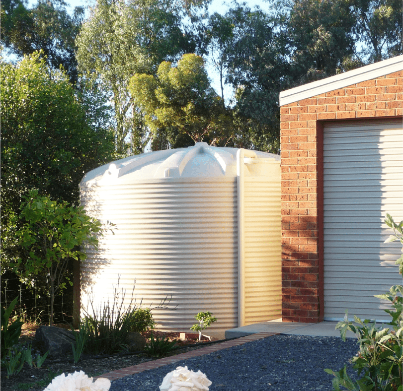 Polymaster Round Water Tanks installed beside a garage shed under huge trees
