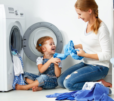 A mom and daughter doing laundry together smiling