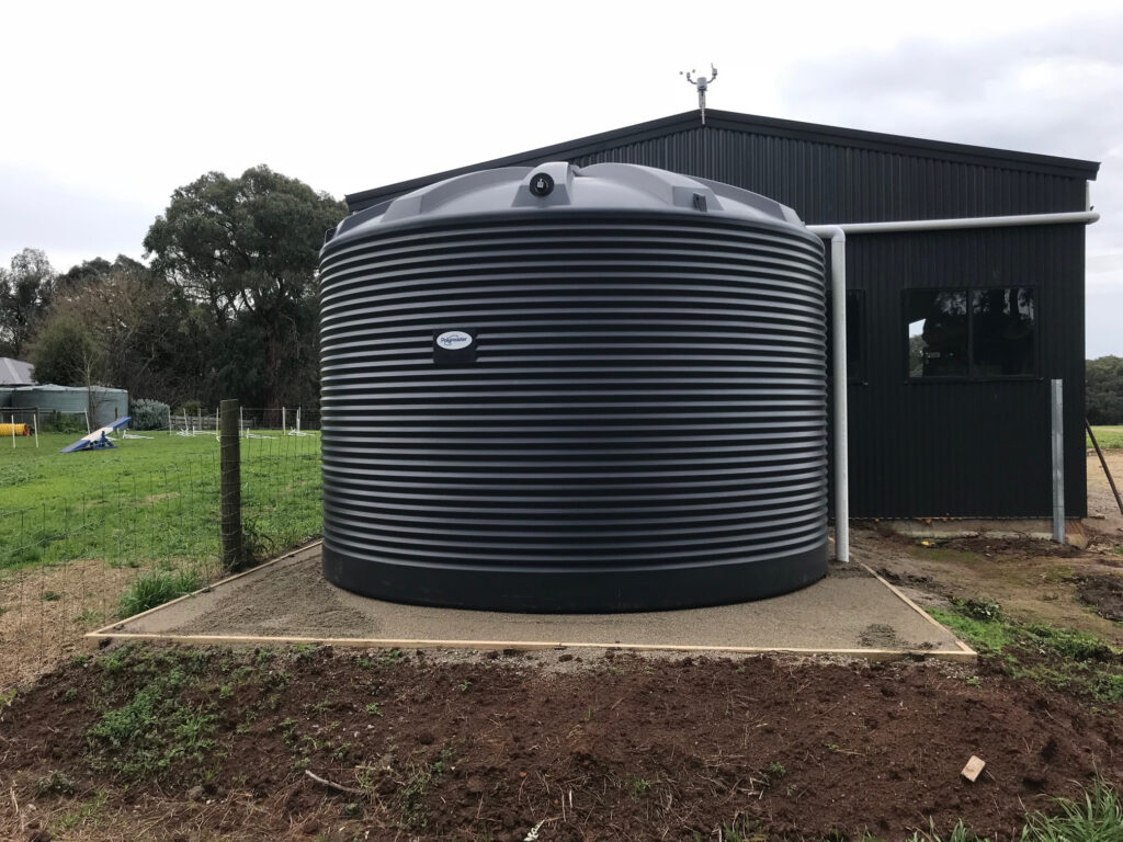 Polymaster black/jasper corrugated water tank installed beside a shed