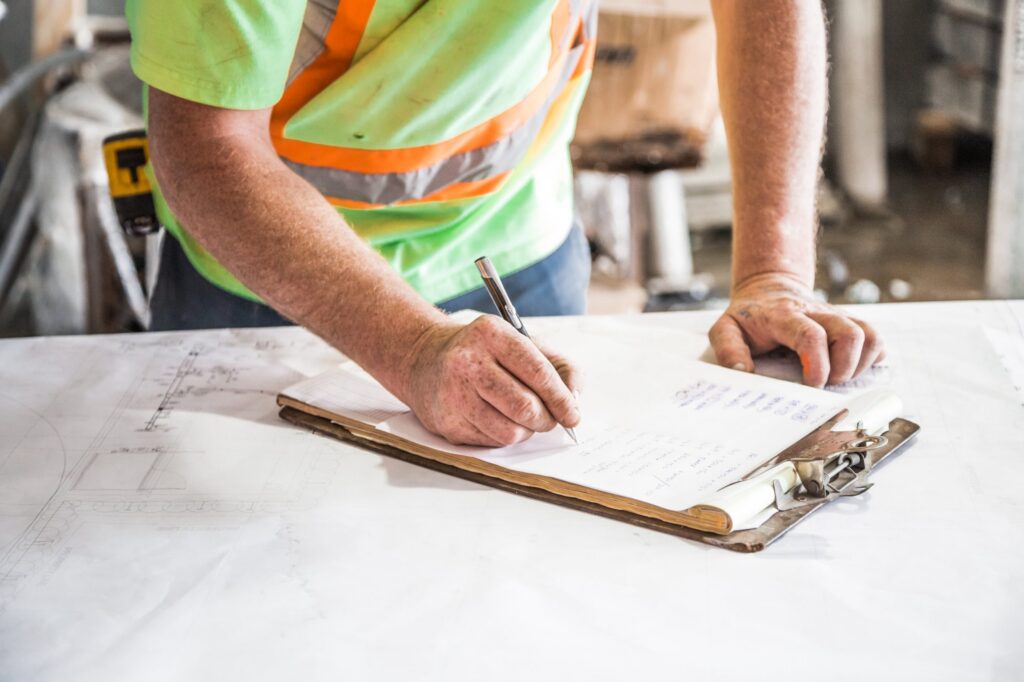 Person writing on paper on top of table