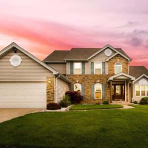 white and brown suburban house with a pink sky